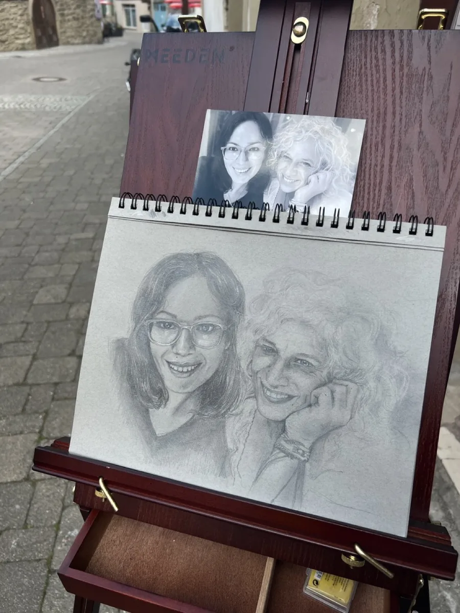 Referenzfoto neben entstehendem Doppelportrait auf der Staffelei